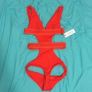 A red one piece swim suit with brown twine lace